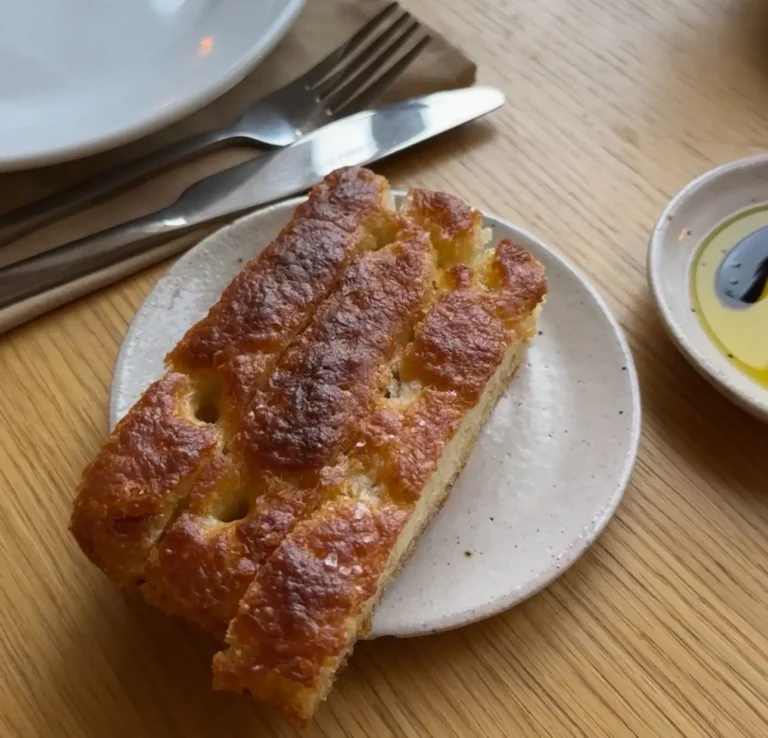 a plate of focaccia served with olive oil and balsamic vinegar at Darling's Restaurant an Italian restaurant in East London Food Scene. The setting is indoors and the dish is placed on a table.