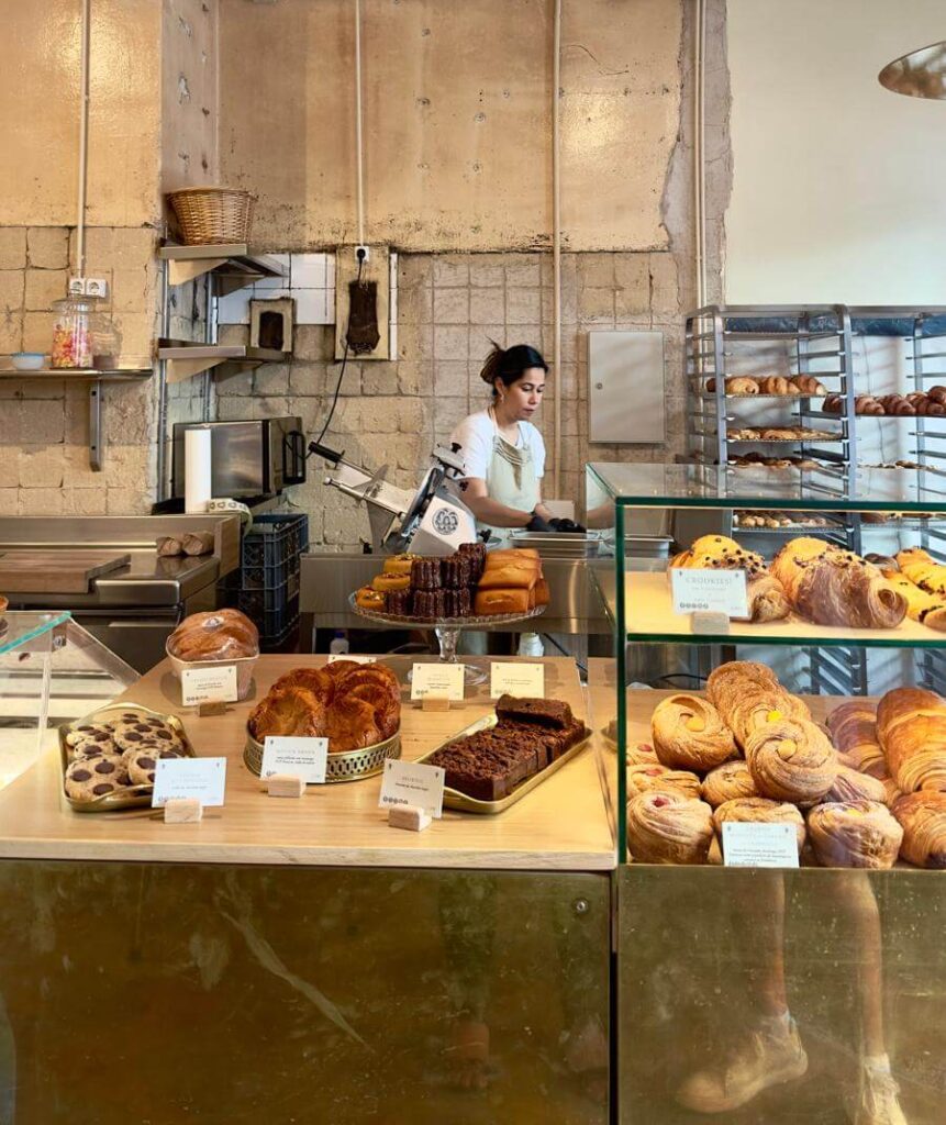 Lully French bakery in Lisbon features a lady behind the counter, surrounded by an array of delicious baked items