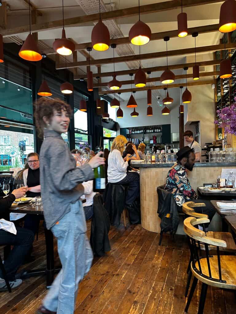 Inside Sune Restaurant, wooden floor, guests sat at the tables, food, drinks and a bar