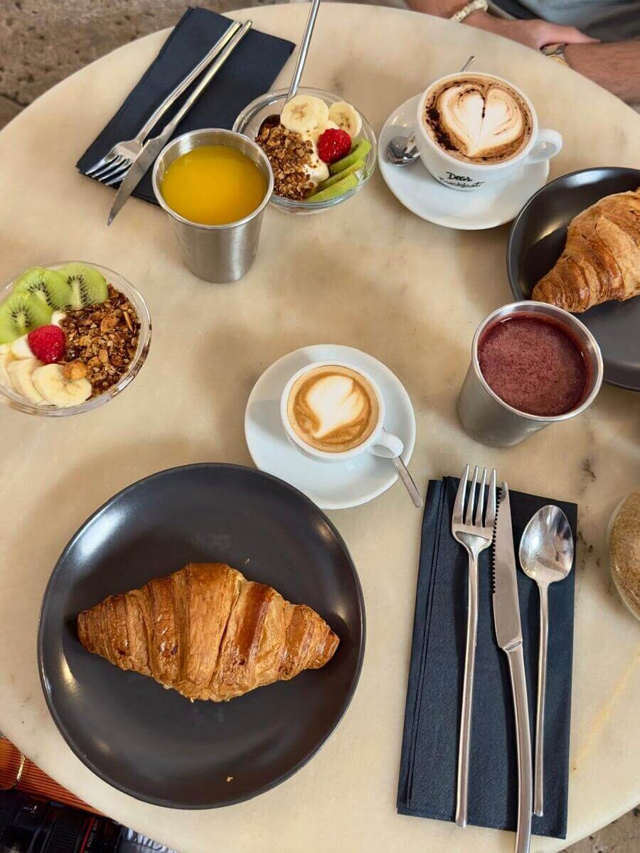 A man seated at a table with a plate of breakfast food, captured at Dear Breakfast in Lisbon
